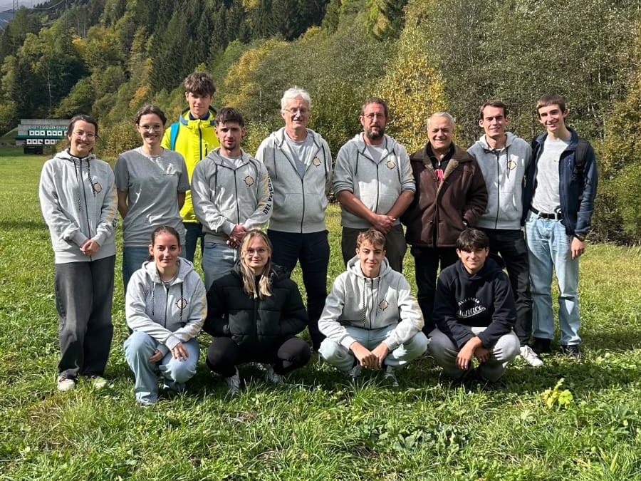 Il gruppo dei soci STV in posa su un prato di Airolo, con il bosco autunnale alle spalle